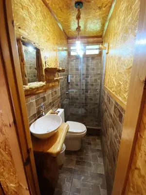 a small bathroom with a toilet and a sink at Lodge La Arboleda - Oxapampa in Oxapampa