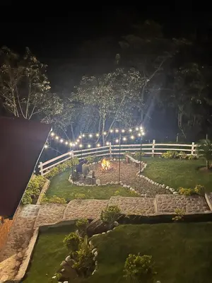 a backyard at night with a fire pit and lights at Lodge La Arboleda - Oxapampa in Oxapampa