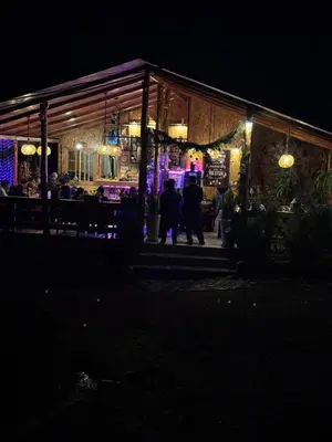 a group of people standing outside of a restaurant at night at Lodge La Arboleda - Oxapampa in Oxapampa