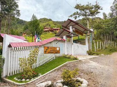 a white fence with a sign on it at Lodge La Arboleda - Oxapampa in Oxapampa