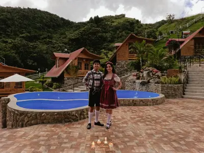 a man and a woman standing in front of a pool at Lodge La Arboleda - Oxapampa in Oxapampa