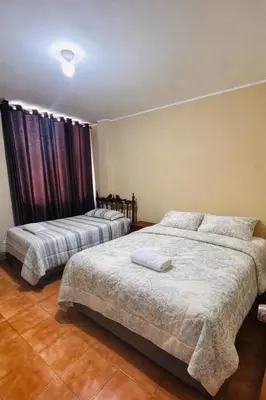 a bedroom with two beds and a window at DEPARTAMENTO Chincha City 1 in Chincha