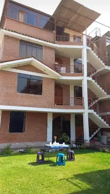 a building with a table in the grass in front of it at Departamento tranquilo en Condominio in Santa Eulalia