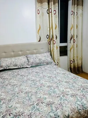a bedroom with a bed with a comforter and curtains at Costa 21 Frente al Mar San Miguel in Lima
