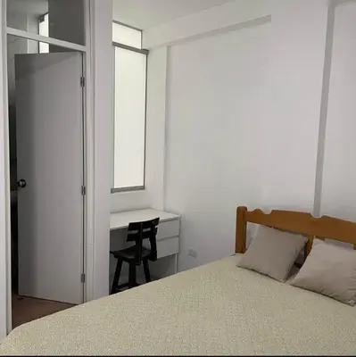 a bedroom with a bed and a desk and a window at Habitación privada con baño propio cerca de Paracas, Pisco in Pisco