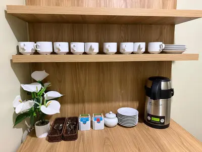 a shelf with cups and plates and a coffee maker at Hospedaje chakana inn in Cusco