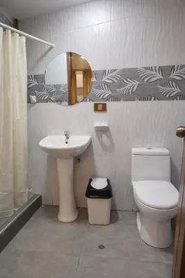 a bathroom with a sink and a toilet and a mirror at Hospedaje chakana inn in Cusco