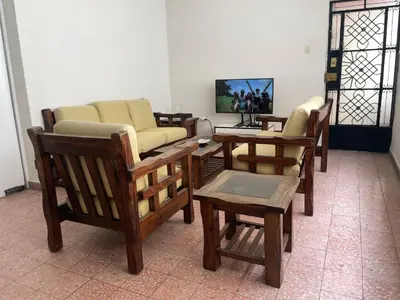 a living room with chairs and tables and a tv at Departamento independiente en Santa Catalina in Lima