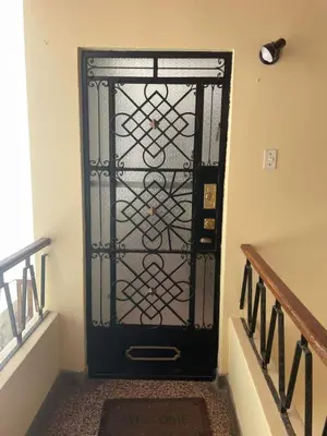 a black door with a iron gate in a hallway at Departamento independiente en Santa Catalina in Lima
