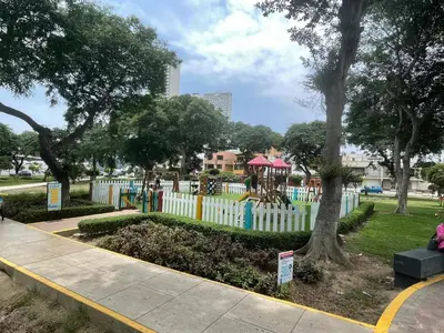 a playground in a park with a white fence at Departamento independiente en Santa Catalina in Lima