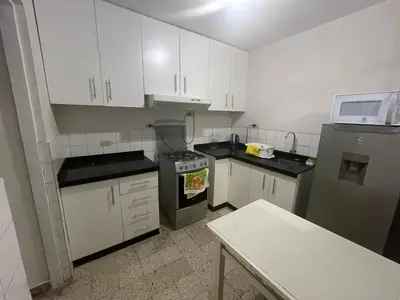 a small kitchen with white cabinets and a stove at Departamento independiente en Santa Catalina in Lima