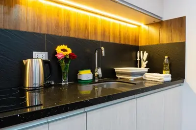 a kitchen counter with a sink and a vase of flowers at Lama Vista Living 401 in Cusco