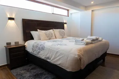 a bedroom with a large bed with towels on it at Lama Vista Living 401 in Cusco