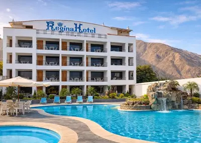 a hotel with a swimming pool and mountains in the background at Regina Hotel in Lunahuaná