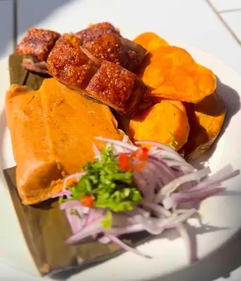 a plate of food with a sandwich and a salad at Regina Hotel in Lunahuaná