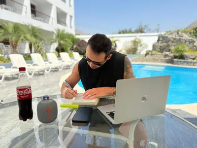 a man sitting at a glass table with a laptop at Regina Hotel in Lunahuaná