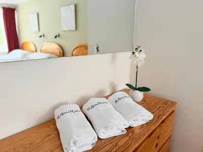 a bathroom with white towels on a wooden shelf at Regina Hotel in Lunahuaná