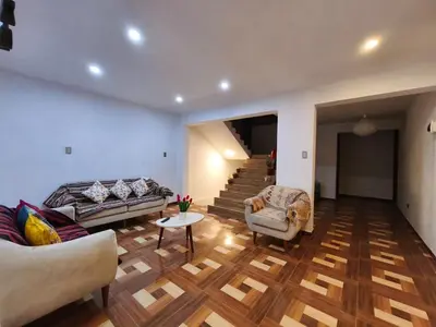 a living room with a couch and chairs and stairs at Huaqui House in Ayacucho