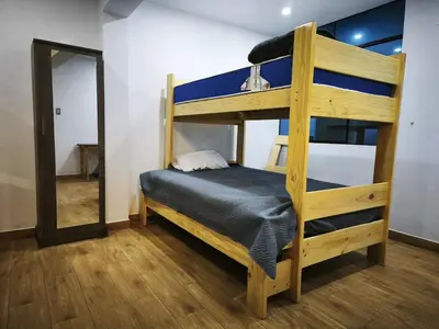 a bunk bed in a room with a mirror at Huaqui House in Ayacucho