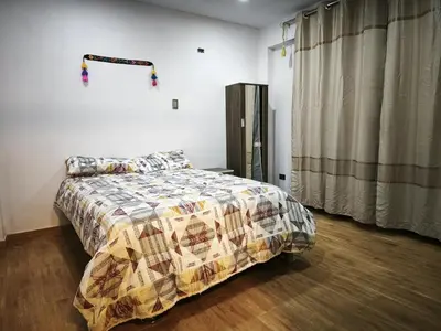 a bedroom with a bed with a quilt on it at Huaqui House in Ayacucho
