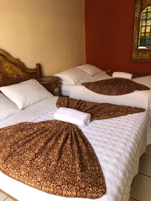 a group of three beds in a room at Hostal Sol Y Luna - Cieneguilla in Cieneguilla
