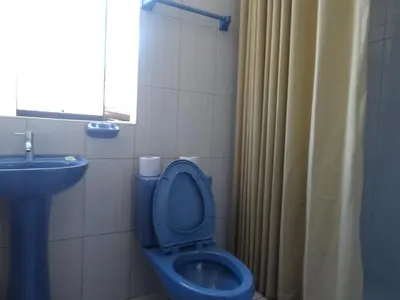 a bathroom with a blue toilet and a sink at Hospedaje Encanto de Chinchero in Chinchero