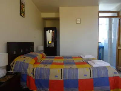 a bedroom with a bed with a colorful blanket at Hospedaje Encanto de Chinchero in Chinchero