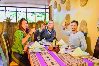 a group of people sitting at a table drinking beer at Albergue Salkantay Chawllay in Santa Teresa