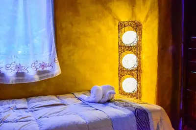 a bed with a stuffed animal sitting on top of it at Albergue Salkantay Chawllay in Santa Teresa