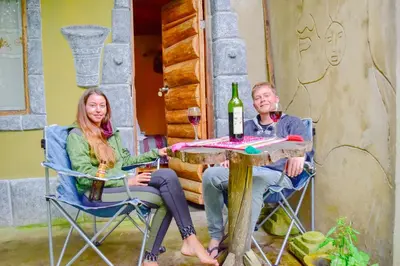 a man and woman sitting at a table with wine glasses at Albergue Salkantay Chawllay in Santa Teresa
