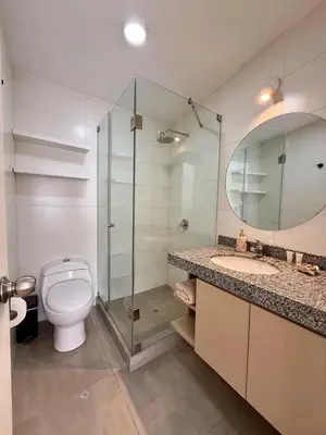 a bathroom with a toilet and a glass shower at Departamento San Martin in Lima