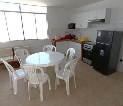 a kitchen with a table and chairs and a refrigerator at Apartamento 301 cerca a la playa in Punta Negra