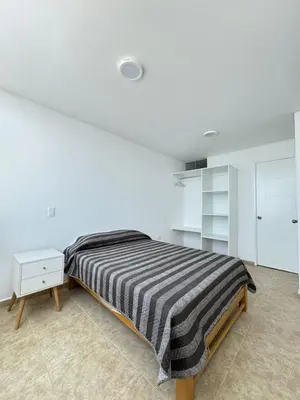 a bedroom with a bed and a white wall at Apartamento 301 cerca a la playa in Punta Negra