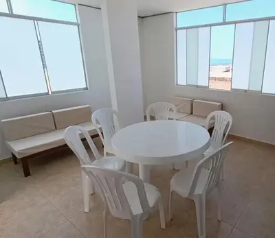 a white table and chairs in a room with windows at Apartamento 301 cerca a la playa in Punta Negra