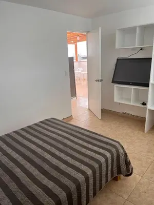 a bedroom with a bed with a striped blanket at Apartamento 302 cerca a la playa in Punta Negra