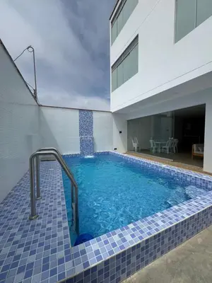 a swimming pool with a tile floor and a building at Apartamento 302 cerca a la playa in Punta Negra