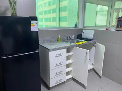 a small kitchen with a sink and a refrigerator at Hermoso apartamento de 3 habitaciones frente a parque en San Isidro in Lima