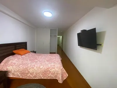 a bedroom with a bed and a flat screen tv at Hermoso apartamento de 3 habitaciones frente a parque en San Isidro in Lima