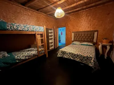 a bedroom with two bunk beds and a chandelier at Tres Gatos Paracas in Paracas