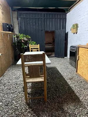 a patio with a table and a chair and a stove at Tres Gatos Paracas in Paracas
