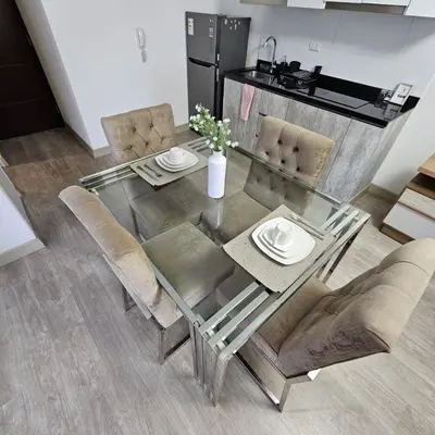 a glass dining room table with chairs and a refrigerator at PERU STAY Barranco in Lima