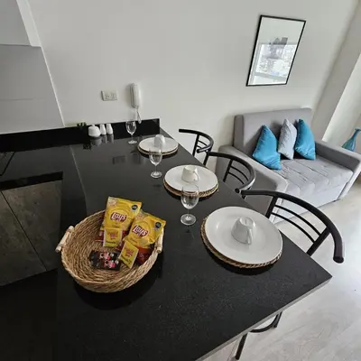 a dining room table with chairs and a table with food at PERU STAY Barranco in Lima