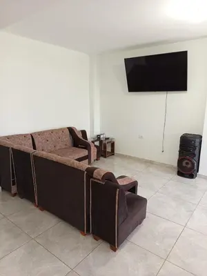 a living room with a couch and a flat screen tv at Casa Rústica in Ica