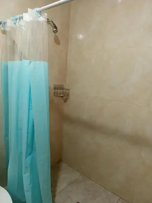 a shower with a blue shower curtain in a bathroom at Casa Rústica in Ica