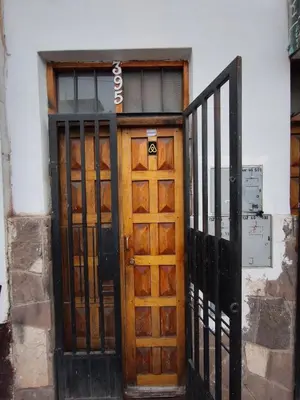 a wooden door in front of a building at Mayu House Inn II a minutos del centro histórico in Cusco