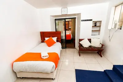 a bedroom with a bed and a chair in it at Mayu House Inn II a minutos del centro histórico in Cusco