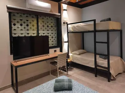 a bedroom with a desk and a bunk bed with a television at Quiet 4BR Villa with Pool & Terrace in Ica