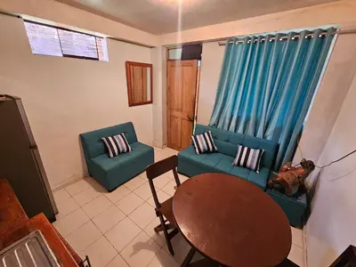 a living room with two blue chairs and a table at Pantaq hostal in Cusco