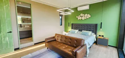 a bedroom with a bed and a brown leather couch at Private 4BR Getaway with Pool & Cinema in Ica