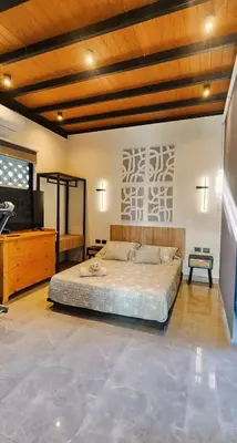 a large bedroom with a large bed and a television at Private 4BR Getaway with Pool & Cinema in Ica